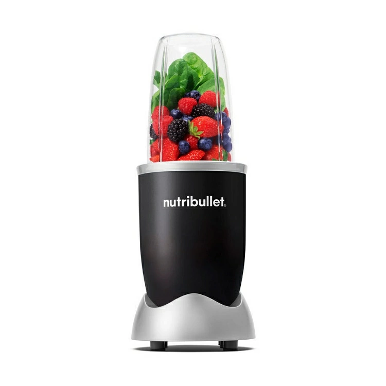 Fekete Nutribullet turmixgép, átlátszó tartállyal, tele bogyós gyümölcsökkel és spenóttal.