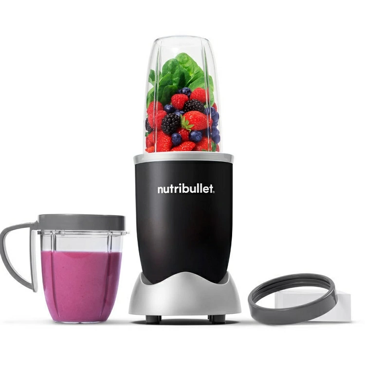 Fekete Nutribullet turmixgép gyümölccsel és spenóttal. Rózsaszín smoothie csészében. Fehér háttér.