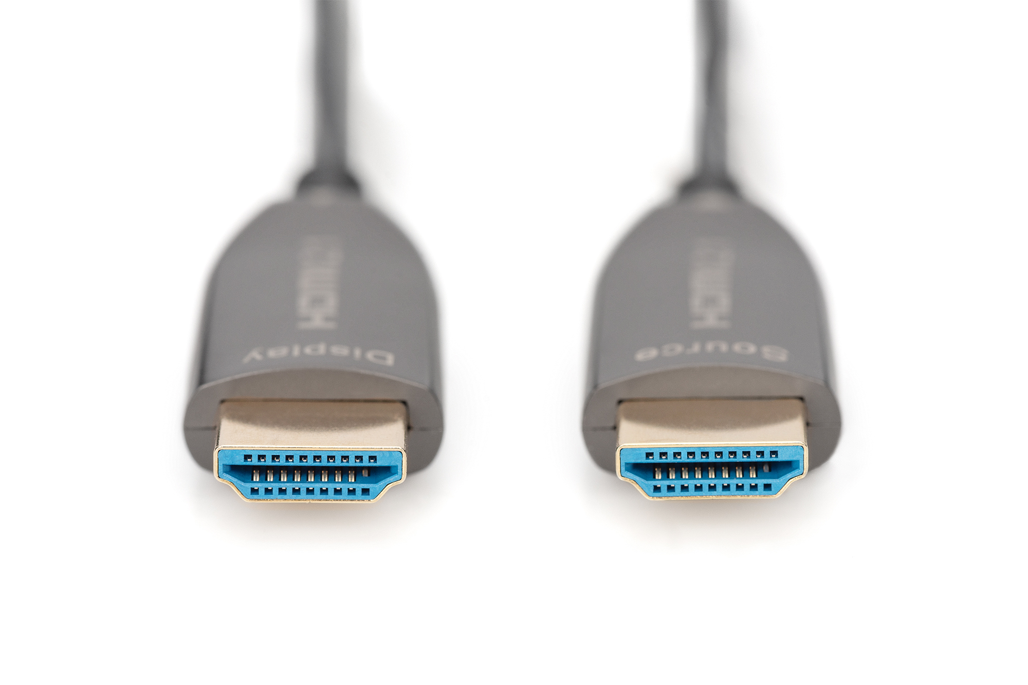 Zwei HDMI-Kabel mit silbernen Steckern und blauen Anschlüssen auf weißer Oberfläche, beschriftet mit Display und Source.