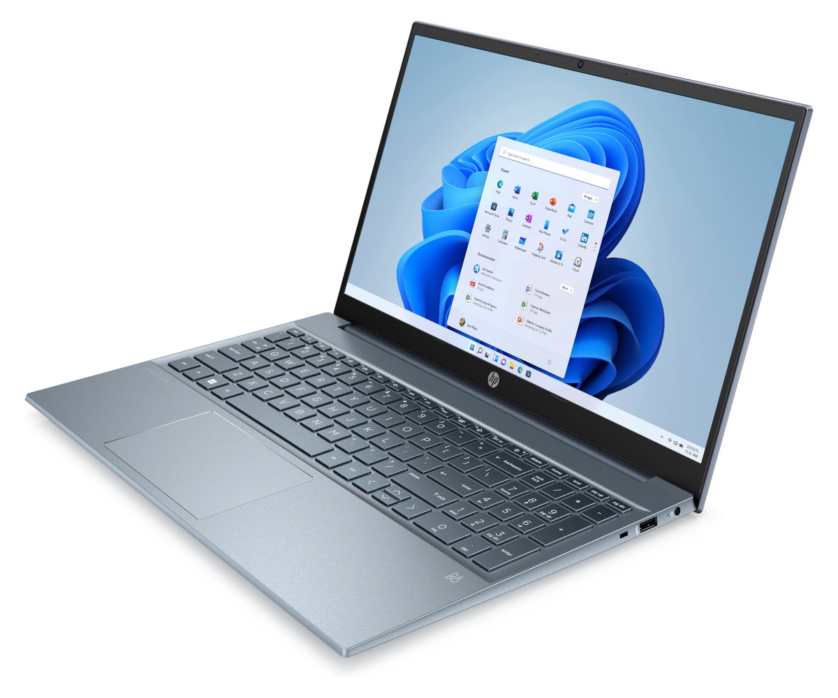 Niebieski laptop otwarty na białej powierzchni, wyświetlający Windows 11. Ujęcie z kąta.