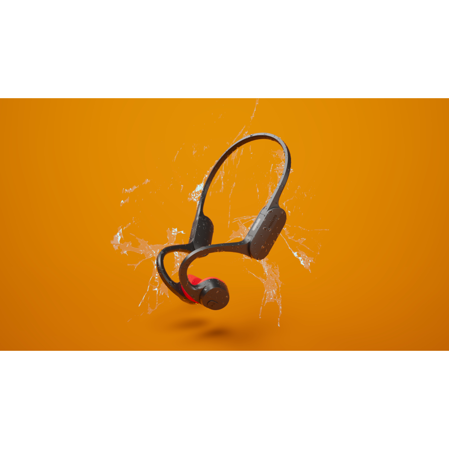Zwarte bone-conduction hoofdtelefoon met rode accenten, zwevend in water, tegen een oranje achtergrond. Opspattend water.