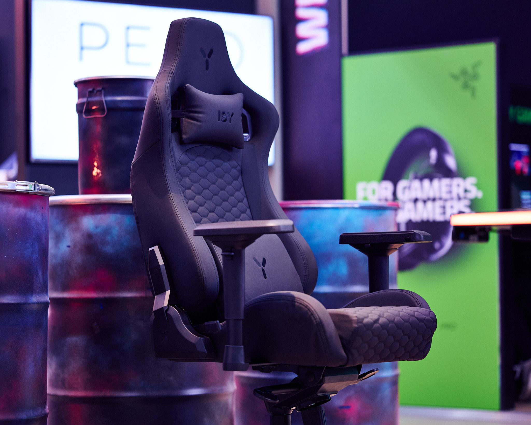 Ein schwarzer Gaming-Stuhl mit Logo und Armlehnen in einer Gaming-Umgebung.