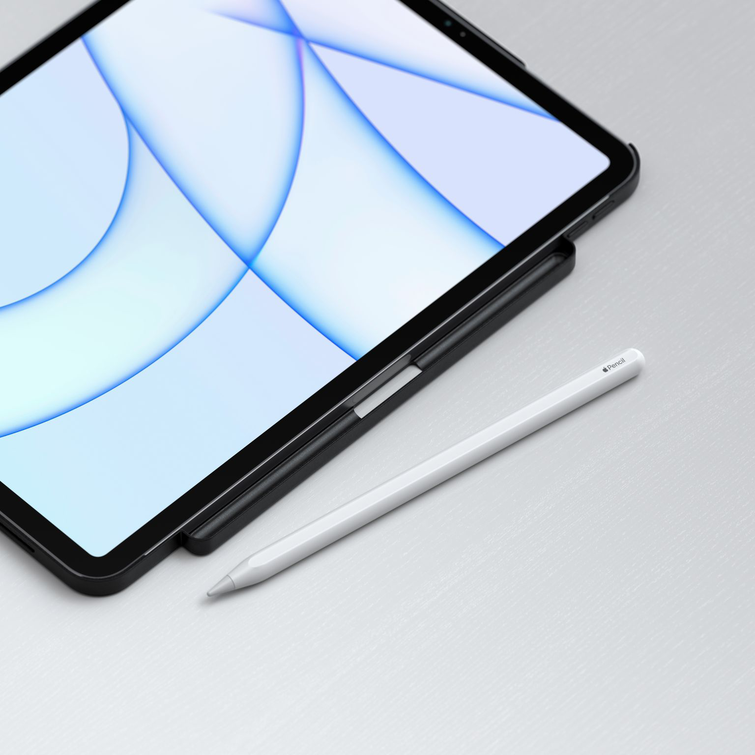 Egy iPad és egy fehér ceruza az asztalon. Az iPad fekete, kijelzővel. A ceruza fehér.