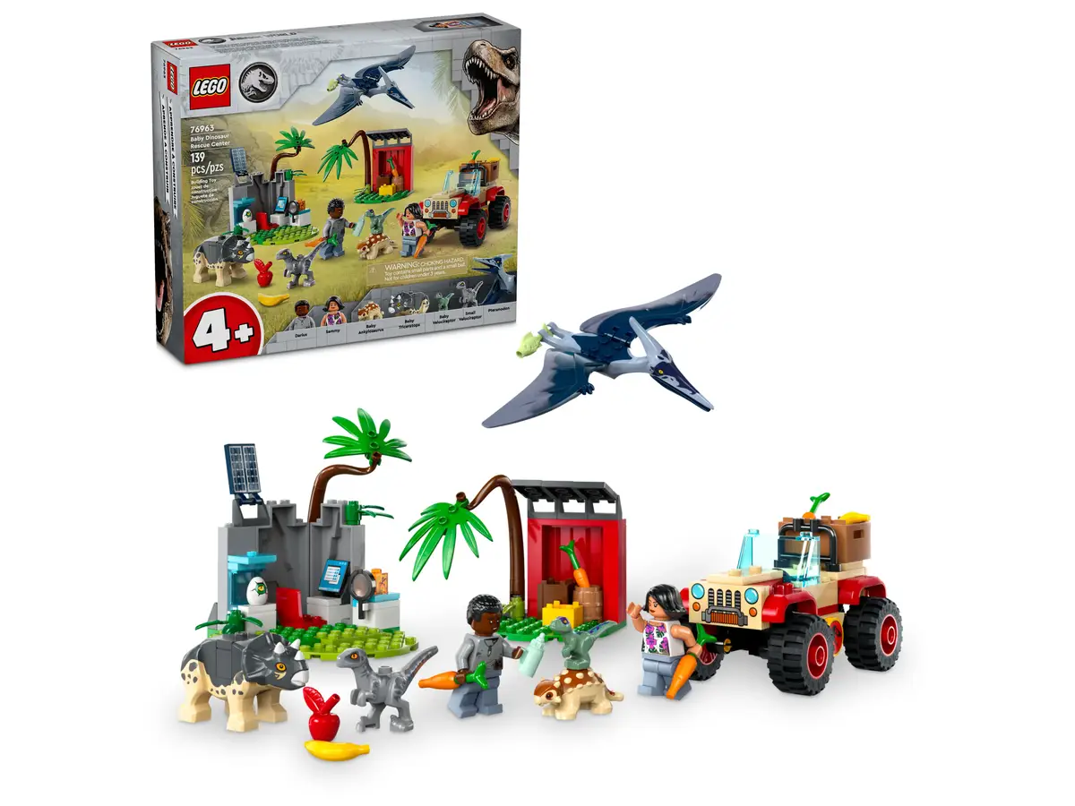 Zestaw Lego: Scena z Jurassic World z dinozaurami, ciężarówką, figurkami i budynkiem. Białe tło.