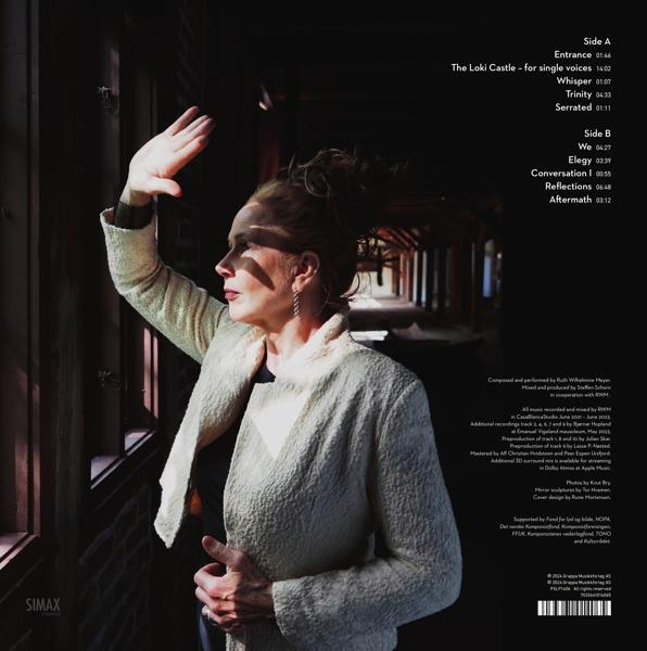 Eine Frau mit heller Jacke schaut nach draußen und hebt die Hand zum Schutz vor der Sonne.