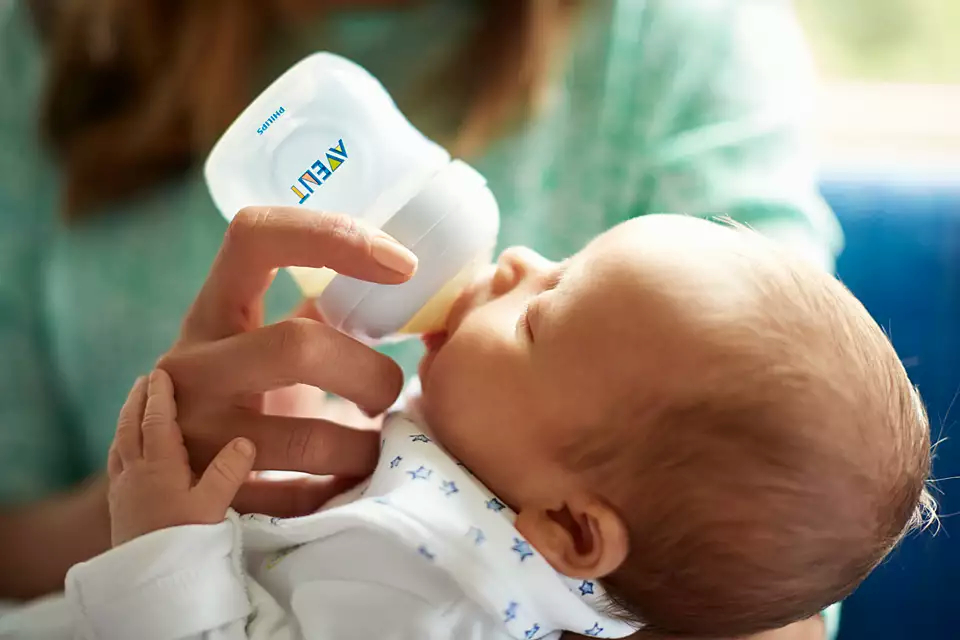 Ein Baby trinkt aus einer Philips Avent Flasche.