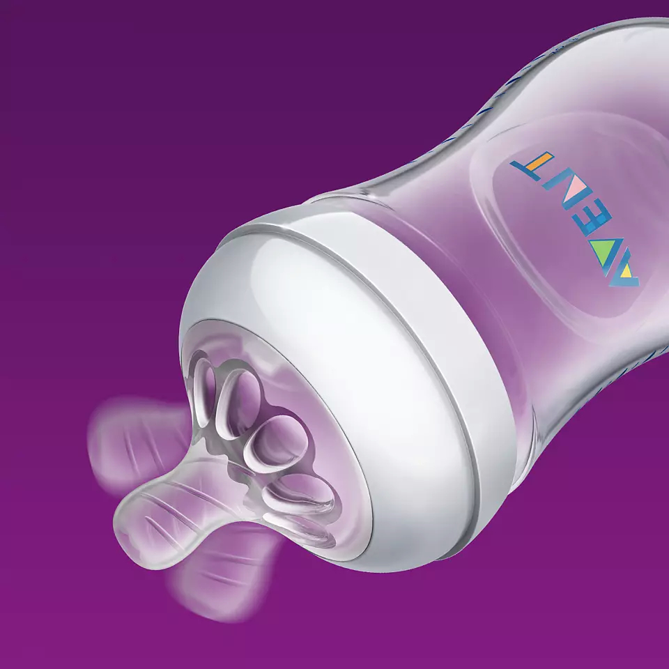 Eine rosa Babyflasche mit weißem Ring und Sauger auf lila Hintergrund.