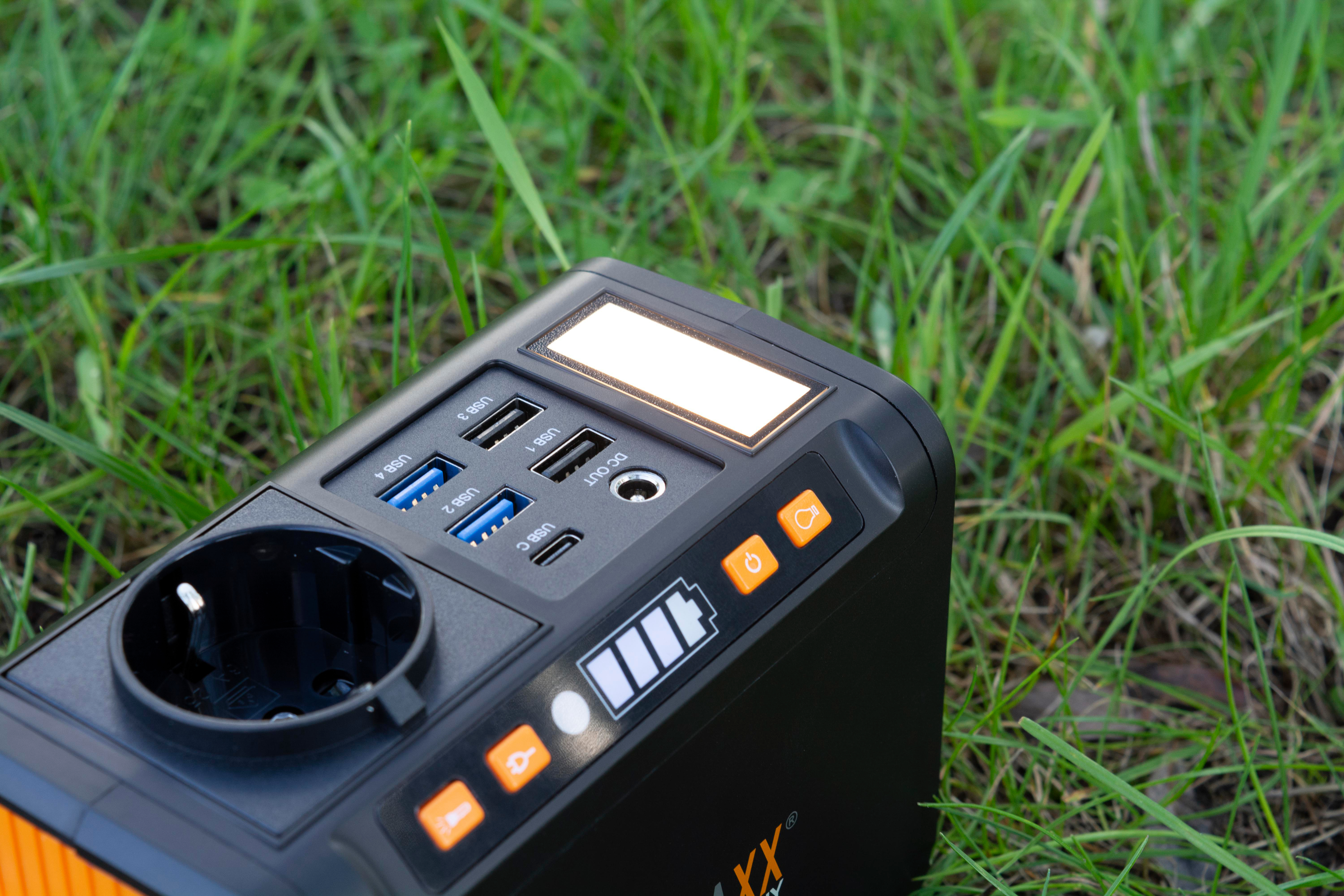 Schwarze und orangefarbene Powerstation auf Gras.