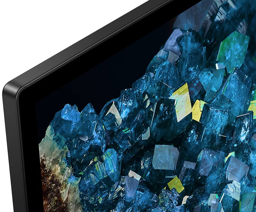 Zbliżenie ekranu telewizora z niebiesko-żółtą grafiką w kształcie kryształu.