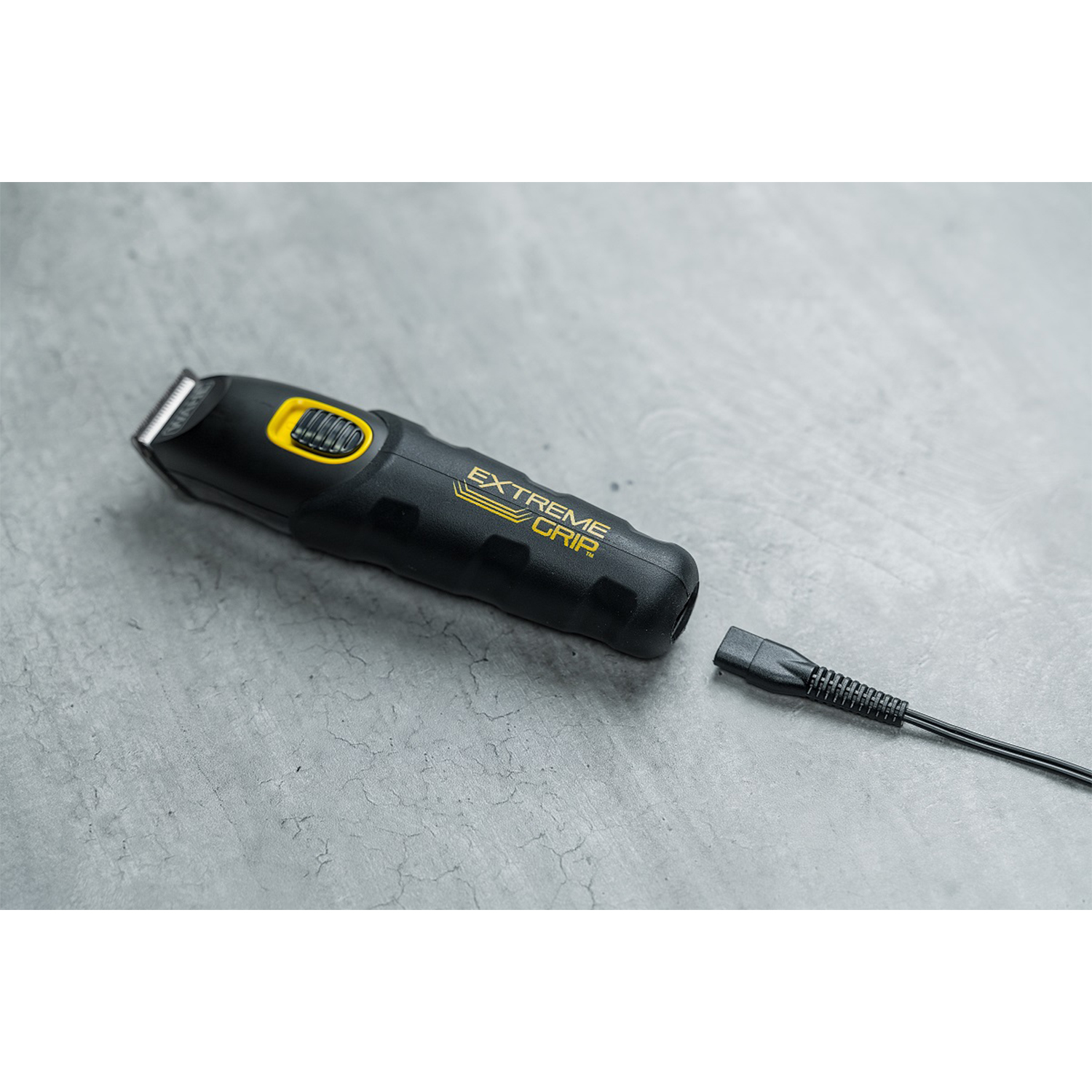 Rifinitore elettrico nero e giallo con cavo di ricarica staccato. Testo: 'Extreme Grip'.