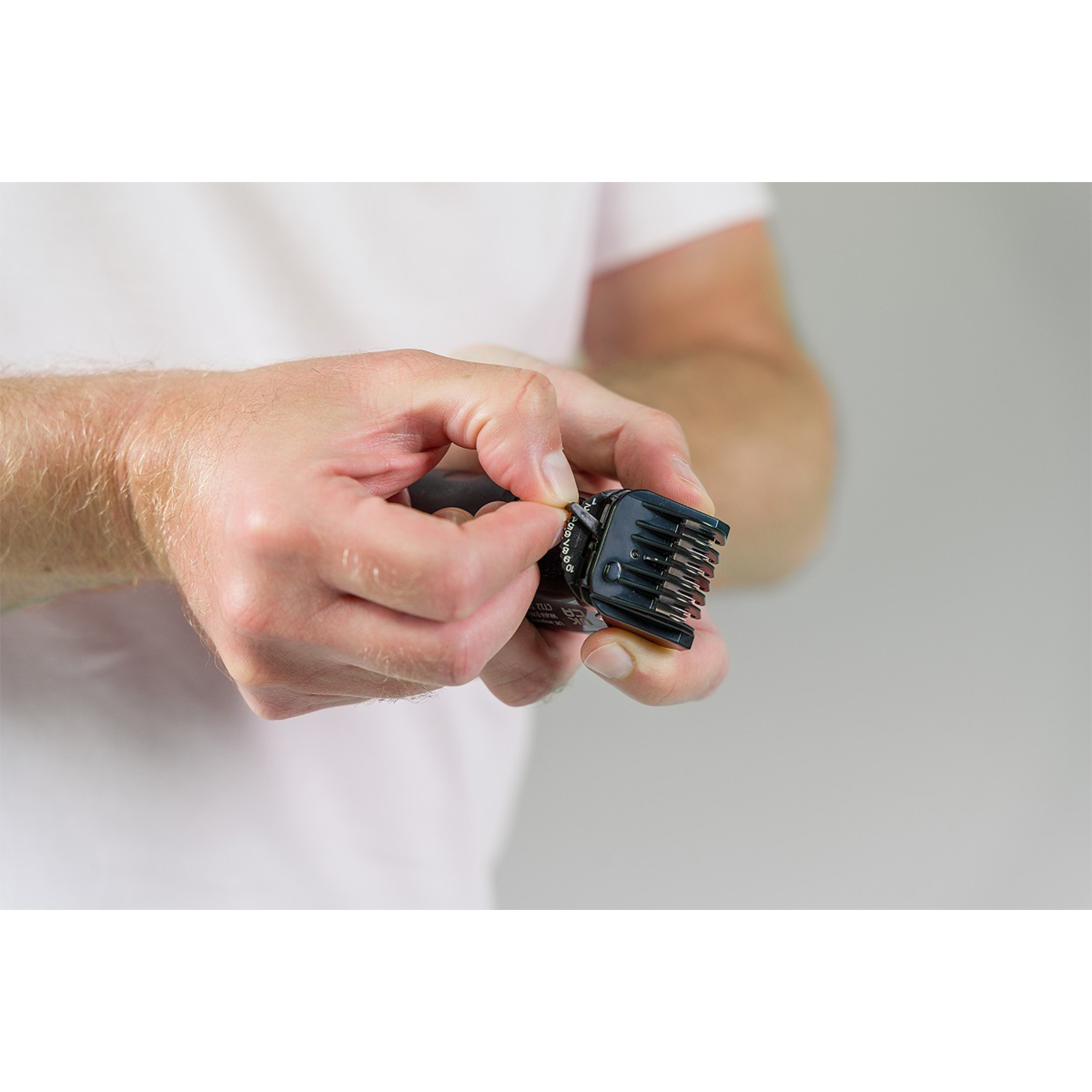 Mani di una persona che regola un accessorio nero per il regolabarba.