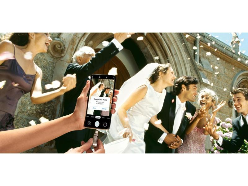 Scena di matrimonio, persone con un telefono che mostra un messaggio "impossibile scattare foto".