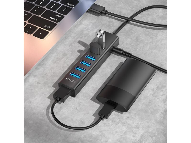 Un hub USB connecté à un ordinateur portable avec plusieurs ports et un adaptateur secteur.