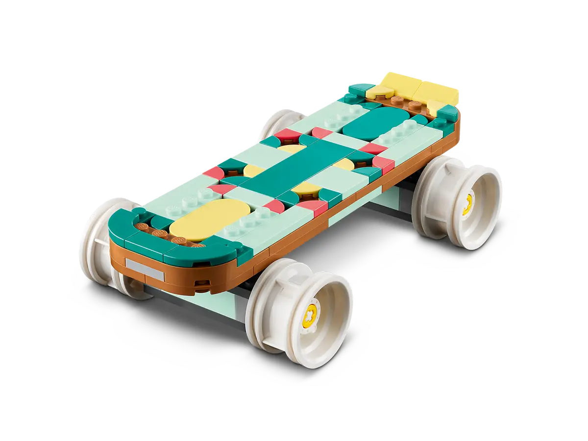 Kolorowa deskorolka Lego. Ma koła i spoczywa na czarnej powierzchni.