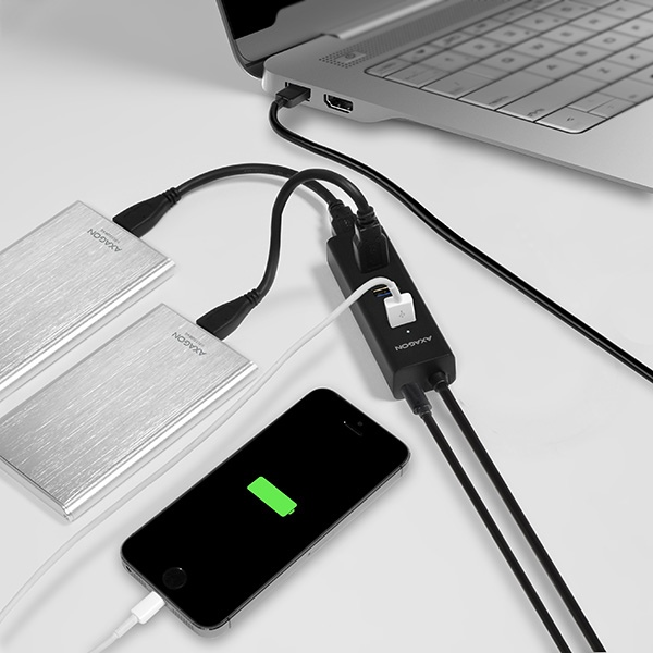 Laptop egy hubhoz csatlakoztatva, külső merevlemezekkel és telefonnal.