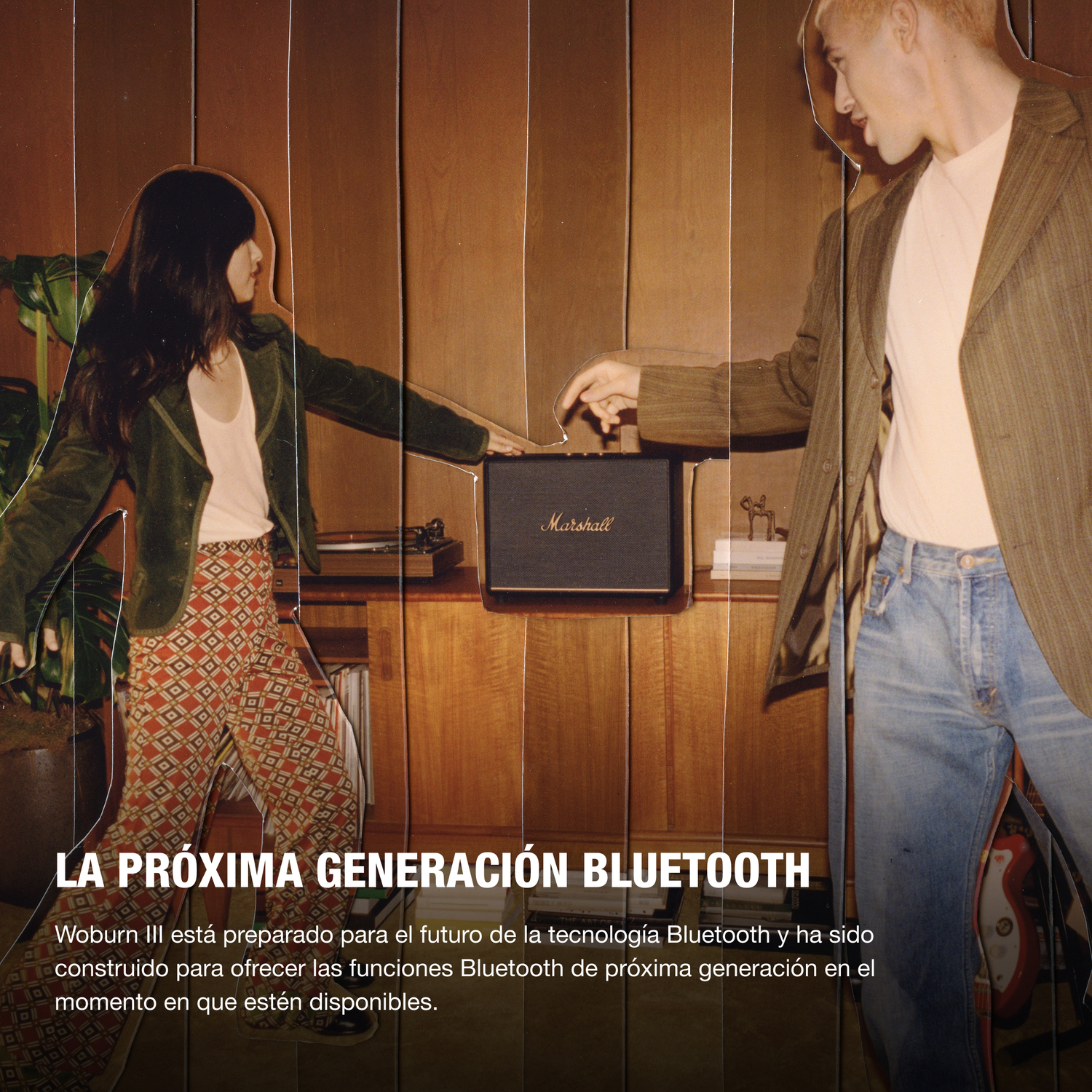 Dos personas con un altavoz Marshall y un tocadiscos, con paneles de madera en el fondo.