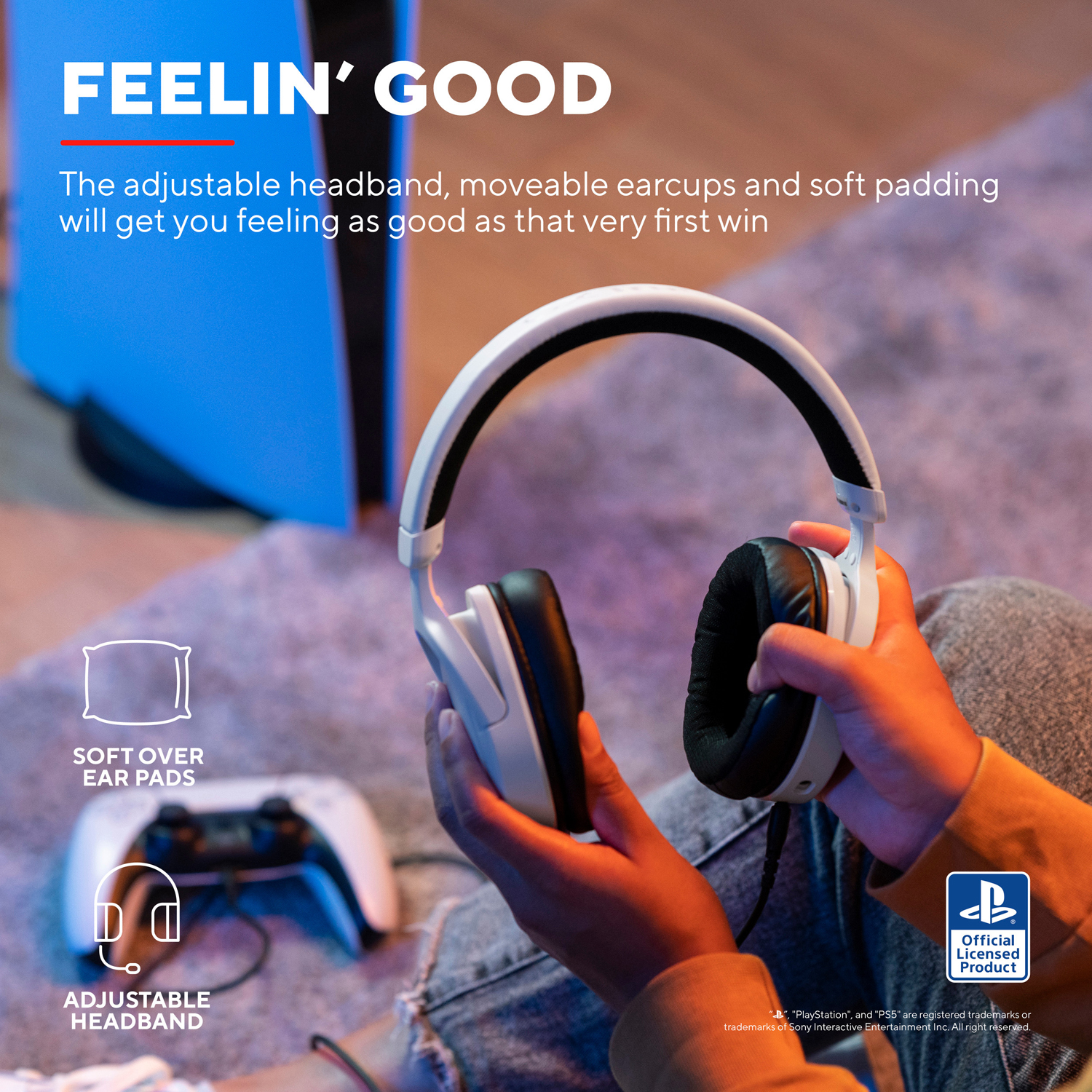 Una persona che tiene un auricolare bianco e nero, con un controller PlayStation nelle vicinanze.