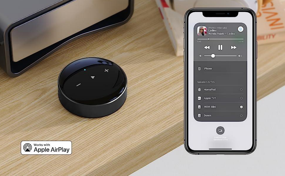 Ein Smart-Home-Gerät und ein Telefonbildschirm mit Musiksteuerungen und Geräteoptionen.