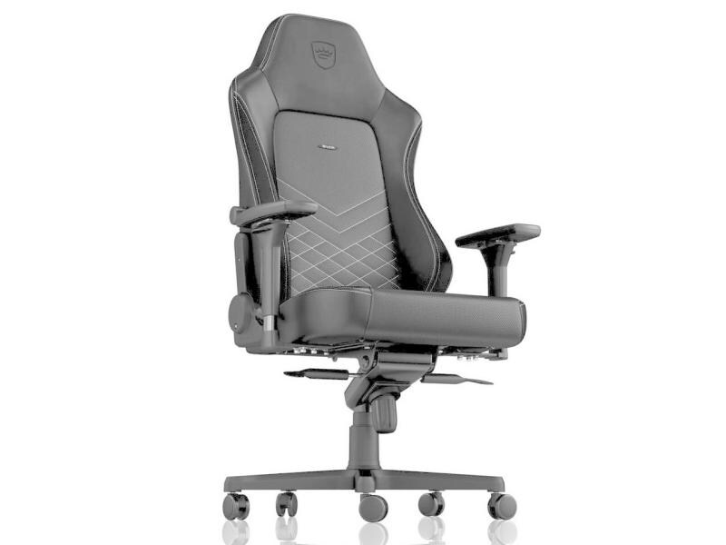 Una sedia da gaming nera con cuciture bianche su sfondo chiaro.