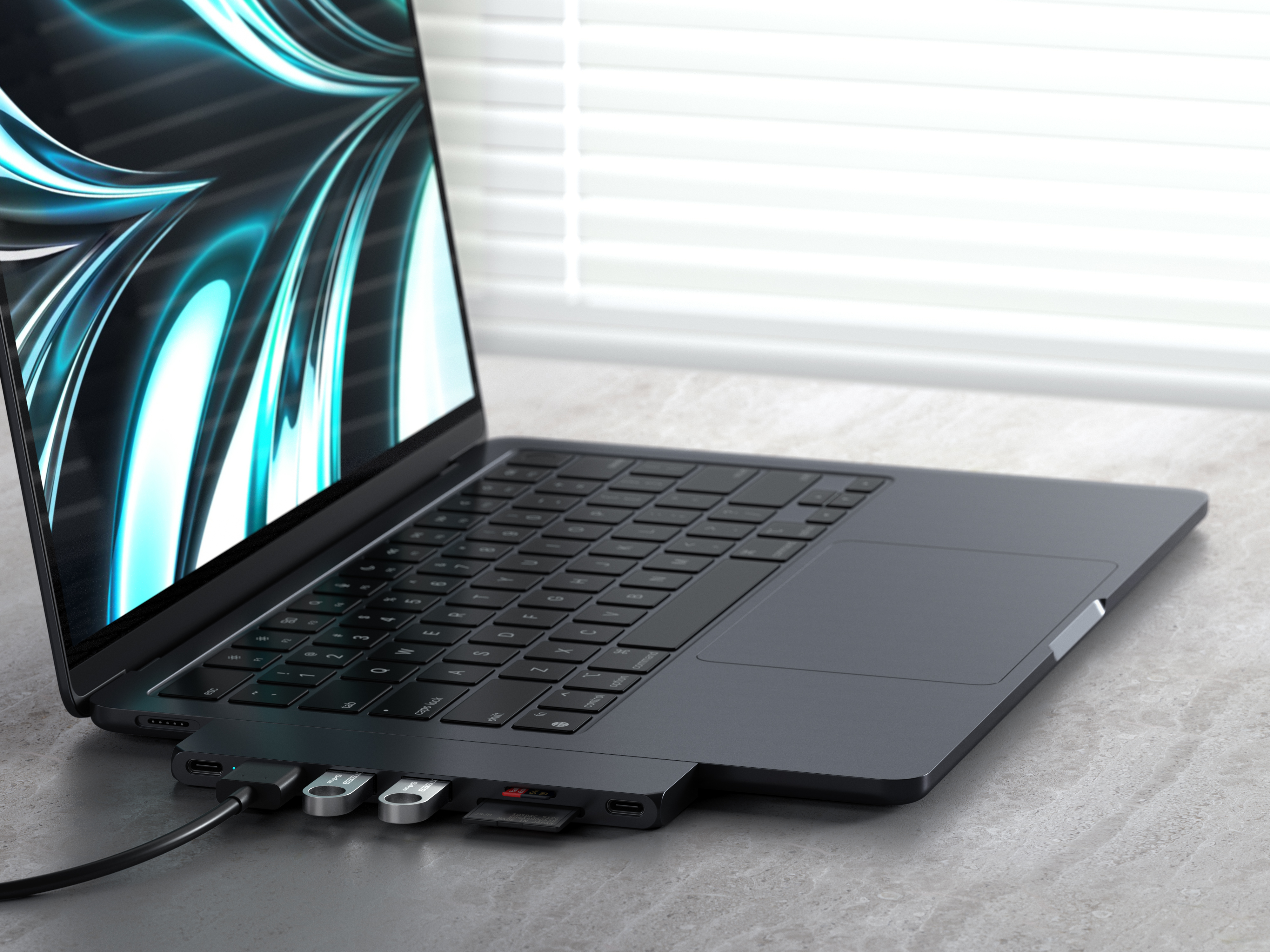 Laptop csatlakoztatott hubbal. USB meghajtók és SD kártya behelyezve. Szürke asztali háttér.