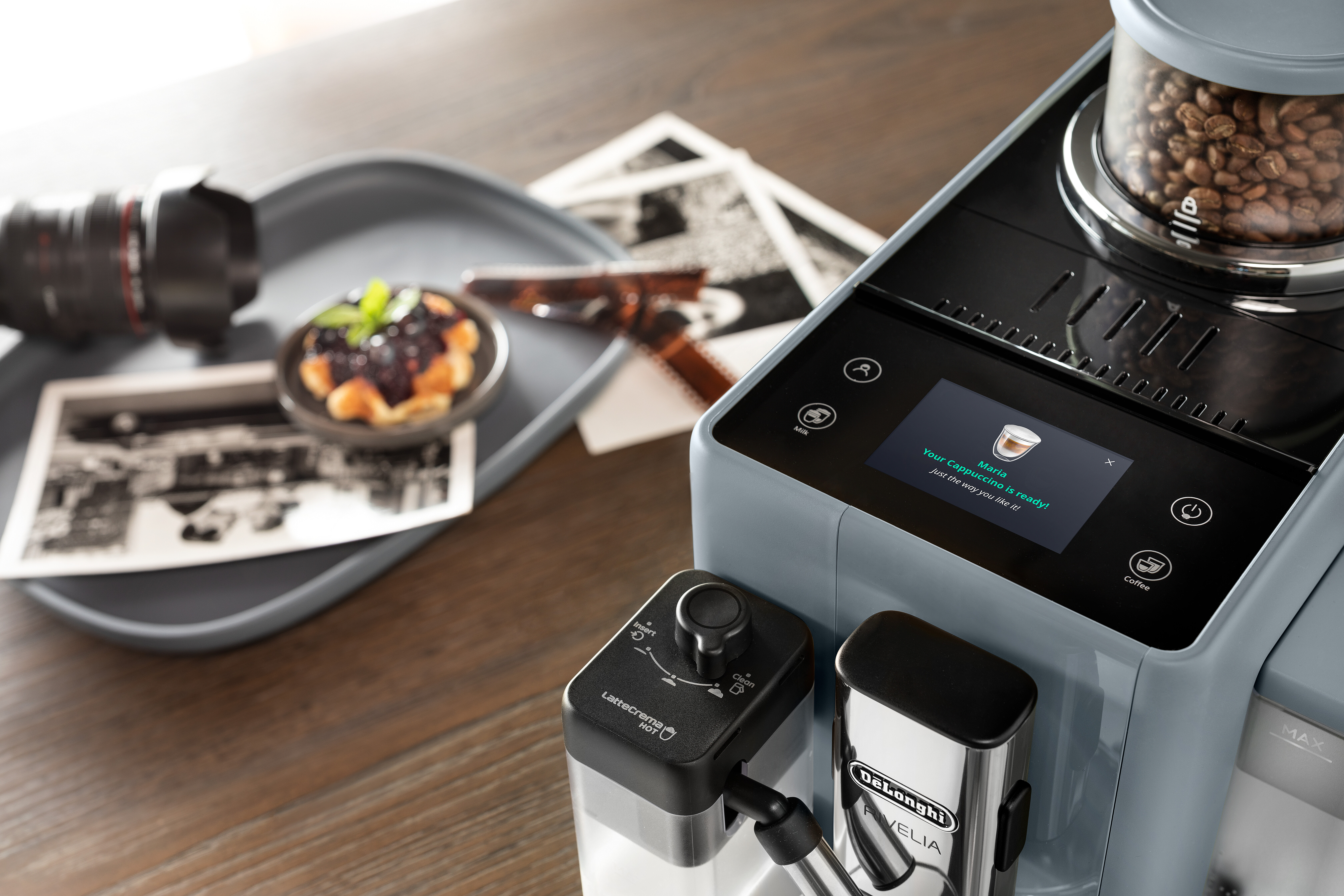 Eine Kaffeemaschine mit Display, Tablett und Kaffeebohnen.