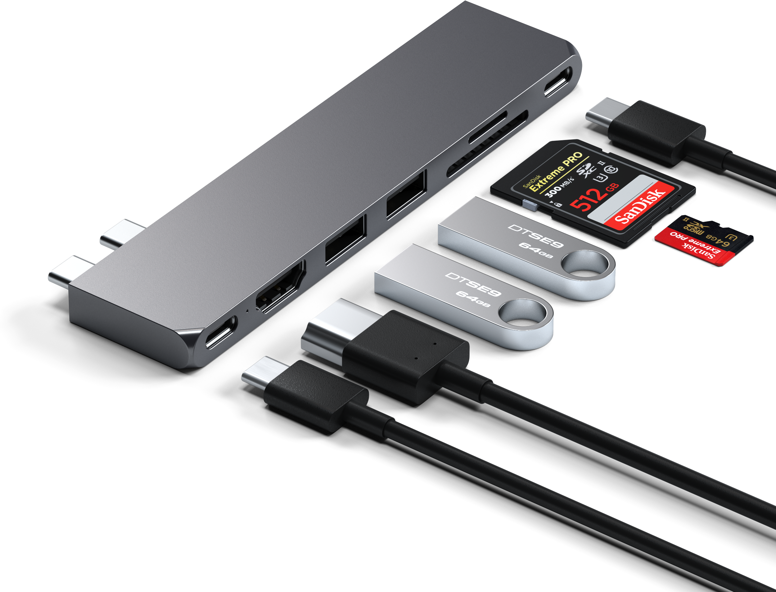 Ezüst hub portokkal és kiegészítőkkel. USB meghajtók, SD kártya és kábelek láthatók.