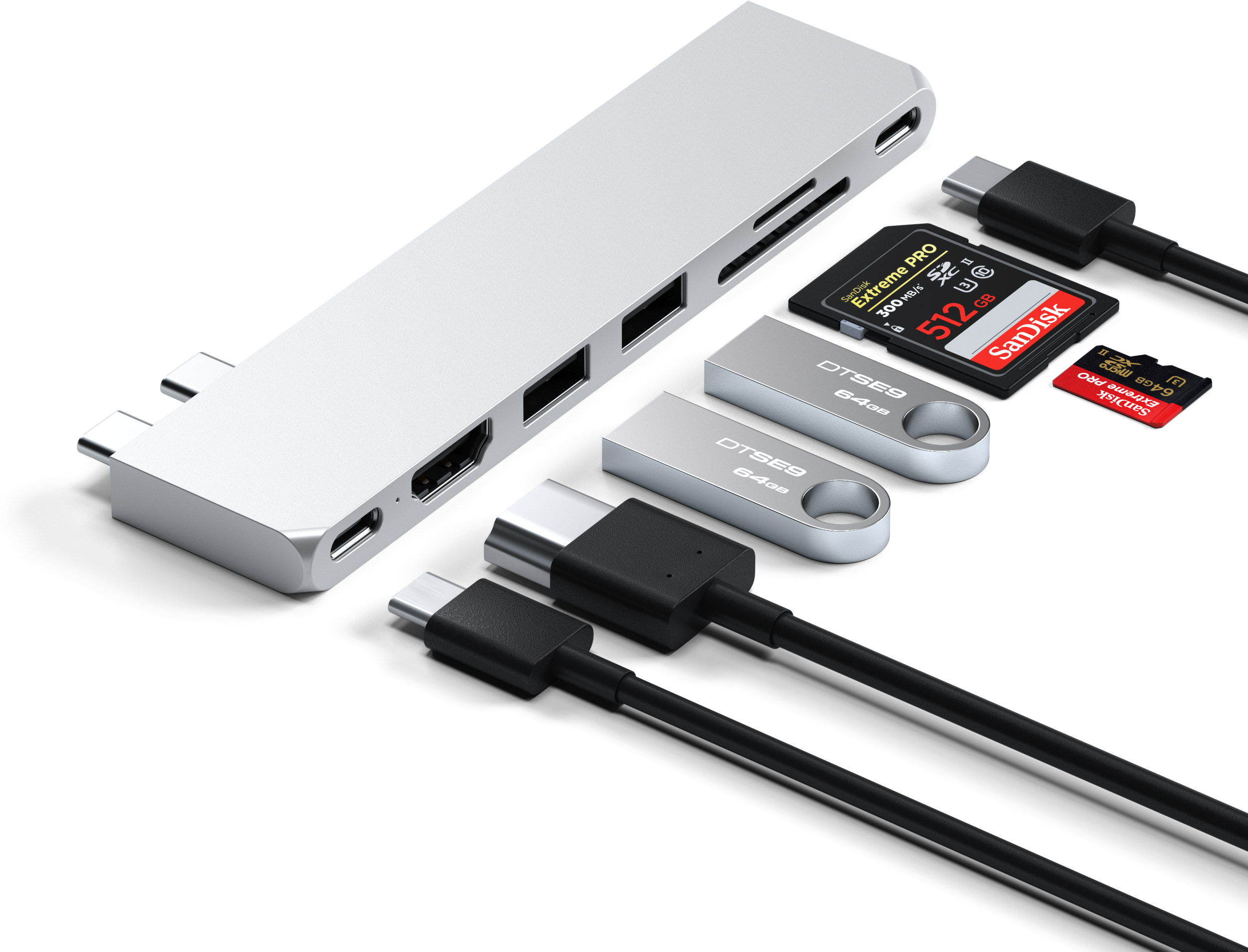 Ezüst hub portokkal és kiegészítőkkel. USB meghajtók, SD kártya és kábelek láthatók.