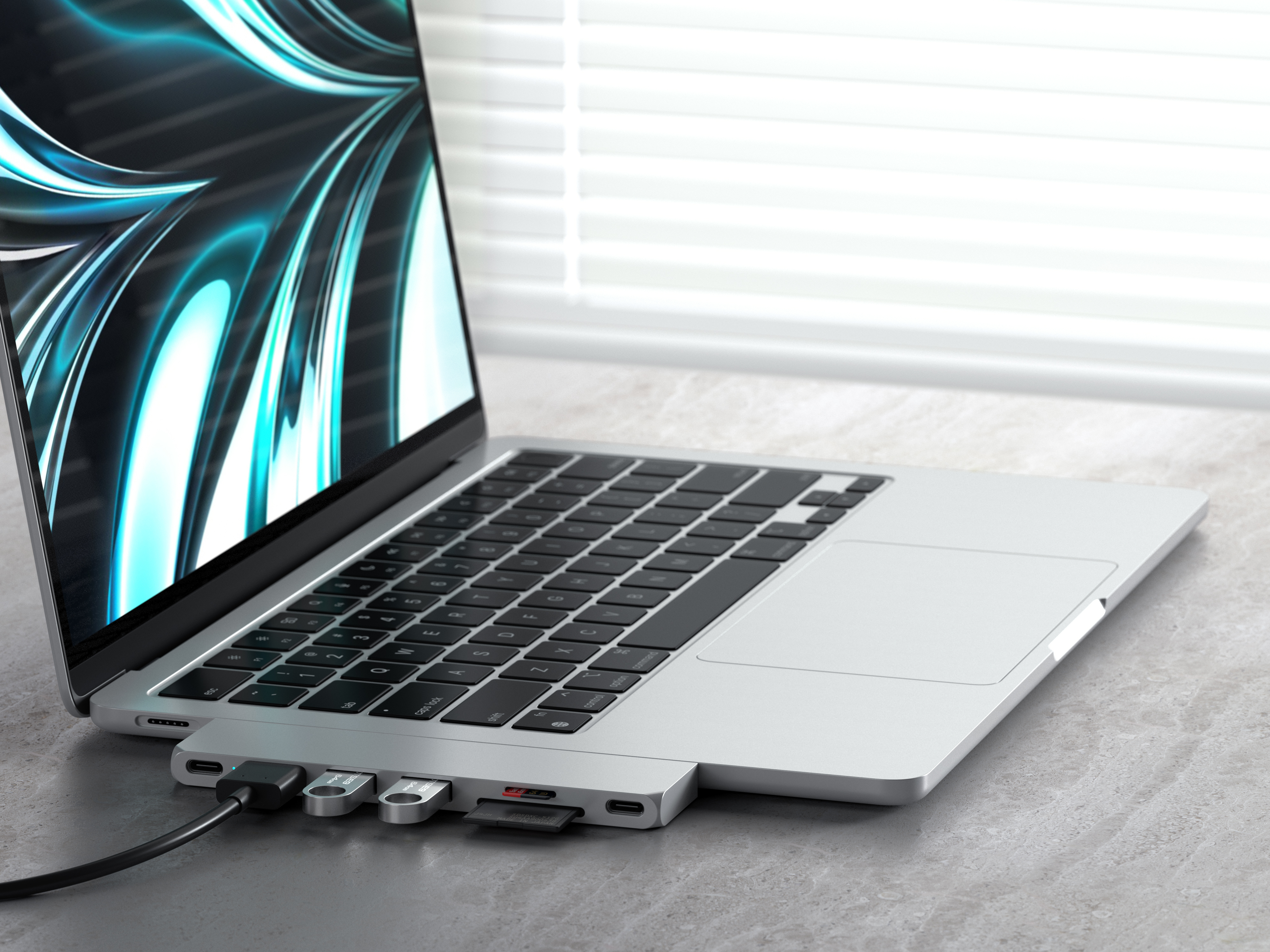 Laptop egy hubbal csatlakoztatva, USB meghajtókhoz és SD kártyához csatlakoztatva. Szürke felület.