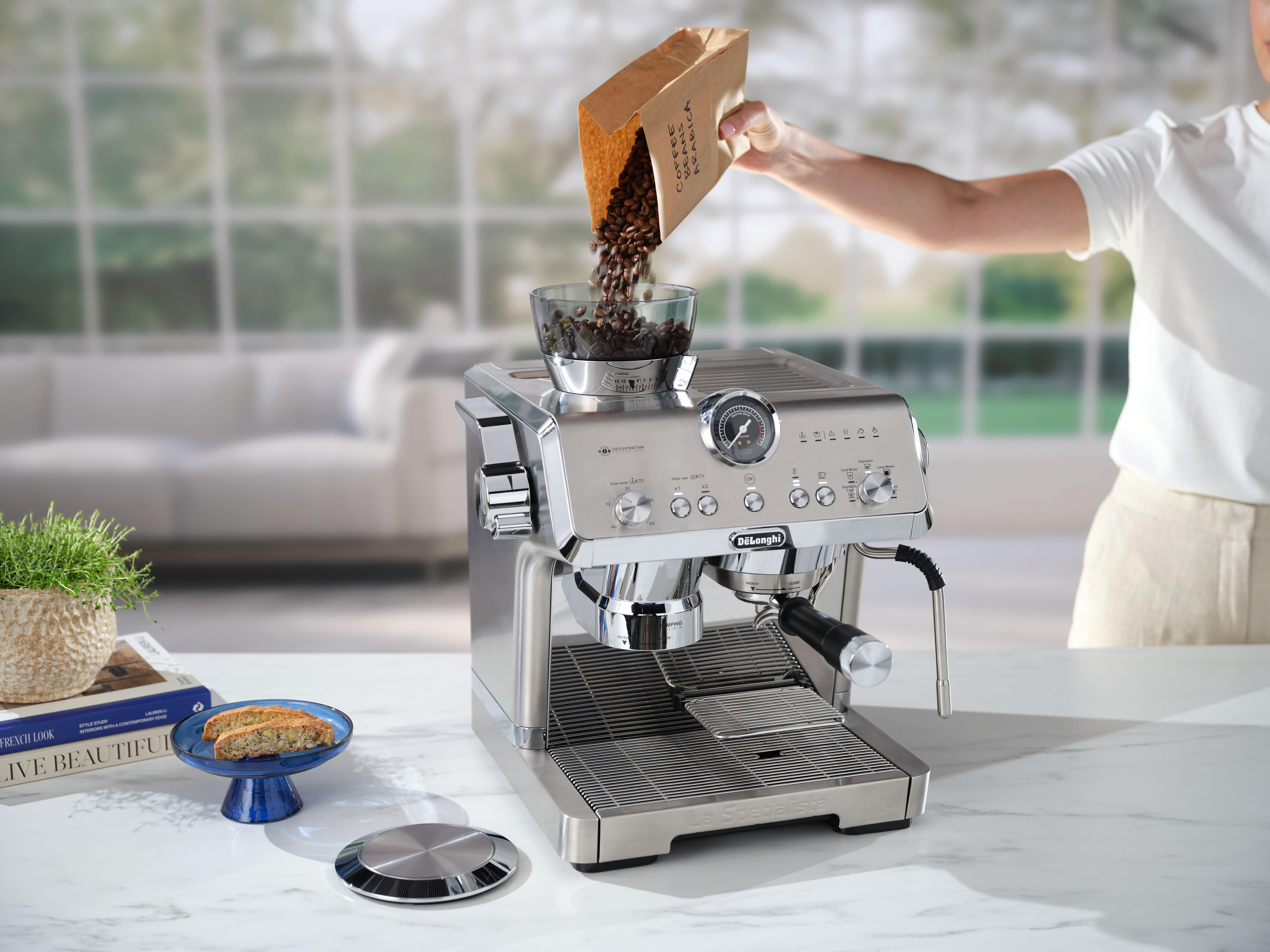 Kaffeemaschine mit Bohnen, die oben hineingegossen werden.