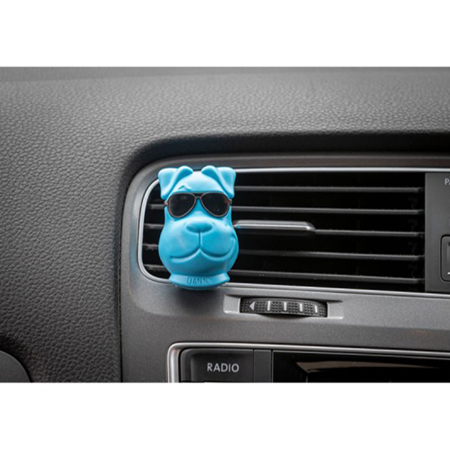 Un deodorante per ambienti a forma di cane blu con occhiali da sole è agganciato alla bocchetta dell'aria di un'auto.