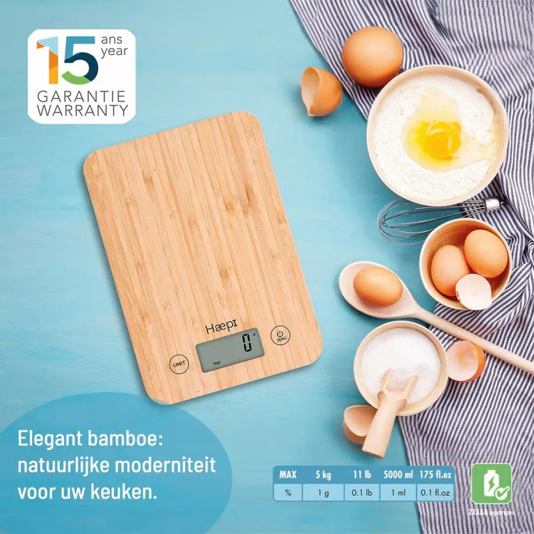 Digital kitchen scale with eggs, flour, sugar, and a whisk on a light blue-checkered surface.