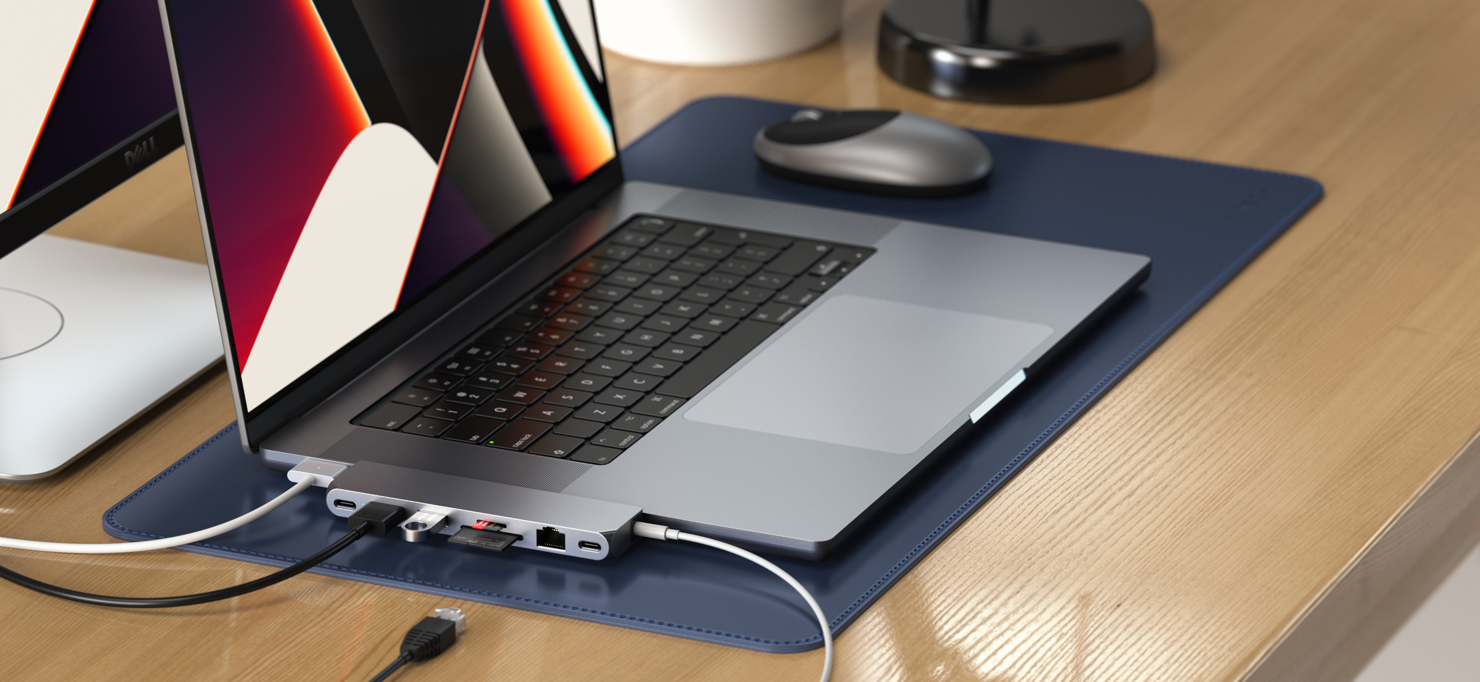 Laptop hubbal, egérrel és USB kábellel fa asztalon. Kék alátét.