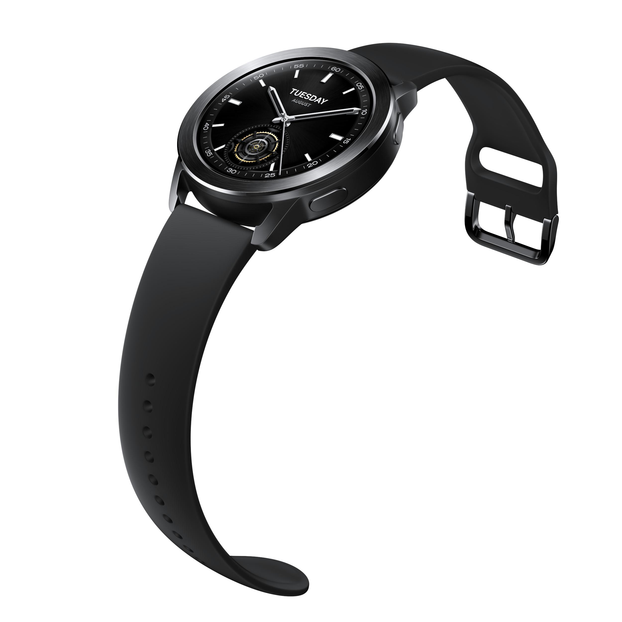 Schwarze Smartwatch mit schwarzem Armband. Die Uhr zeigt Dienstag. Weißer Hintergrund.