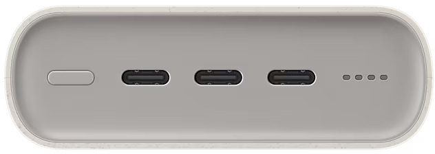 Közelkép egy világosszürke power bankról, három USB-C porttal és egy bekapcsológombbal.
