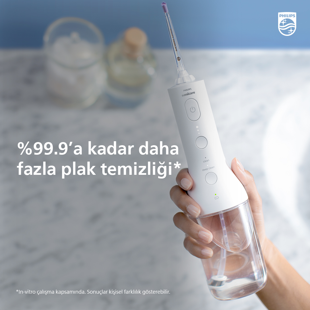 Bir kişi, Philips Sonicare ağız duşu tutuyor, plak temizleme hakkında metinle.