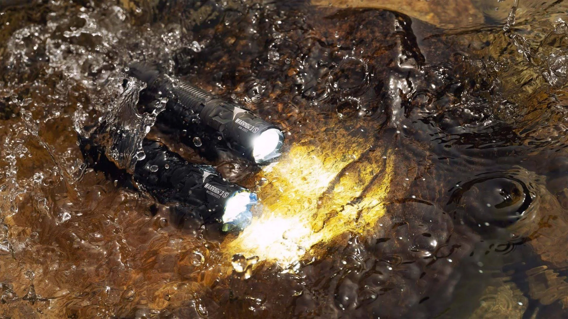 Zwei schwarze Taschenlampen, die im Wasser leuchten.