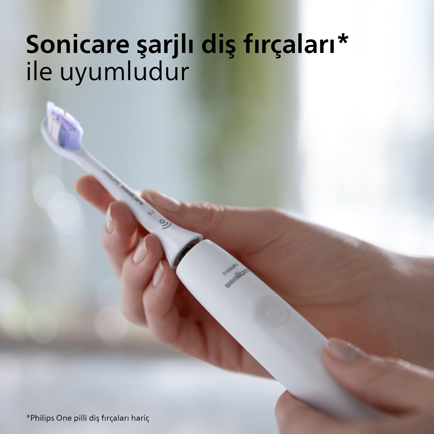 Bir el, mor başlıklı beyaz bir diş fırçası tutuyor.