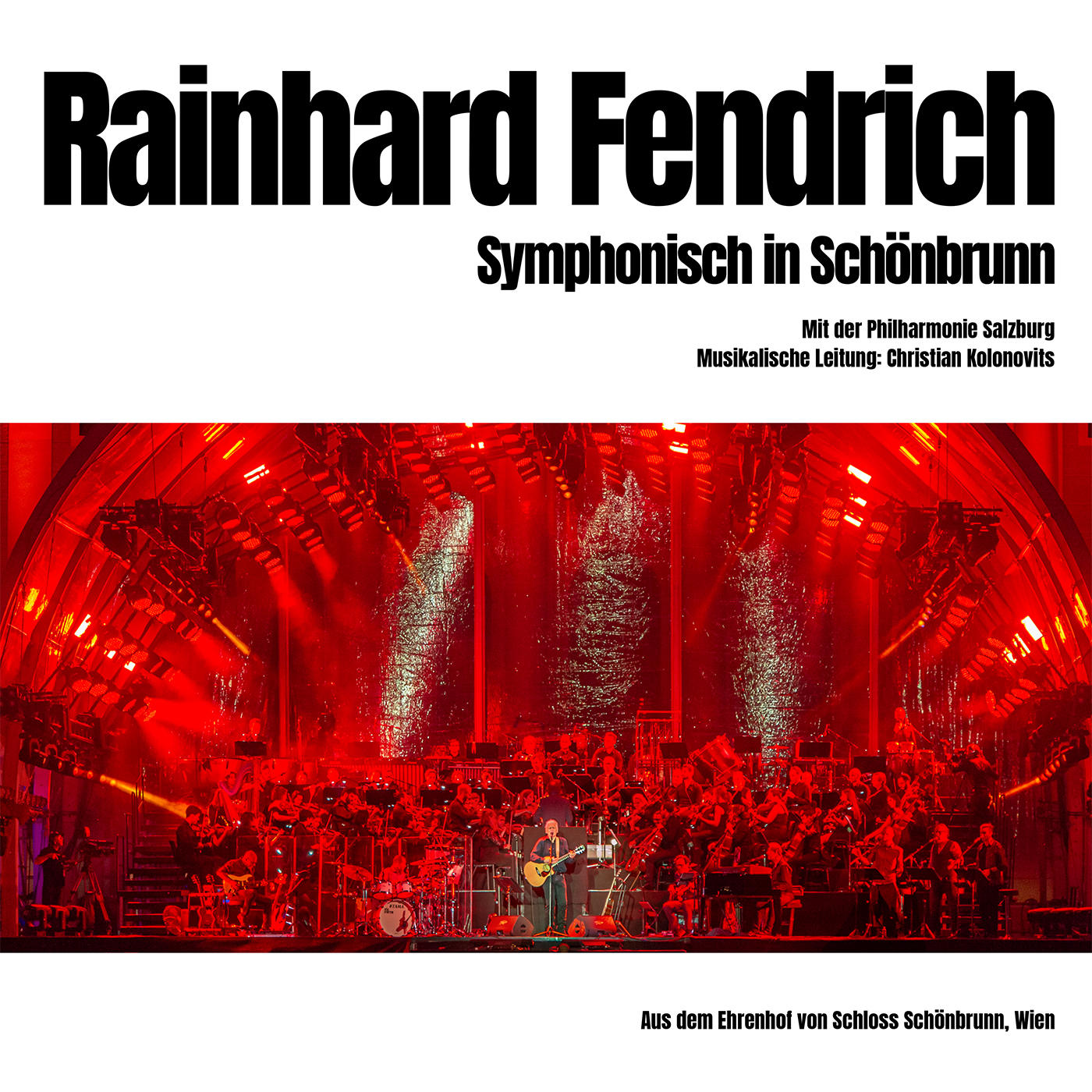 Reinhard Fendrich Albumcover: Orchester auf der Bühne mit roter Beleuchtung. Der Text befindet sich oben und unten im Bild.