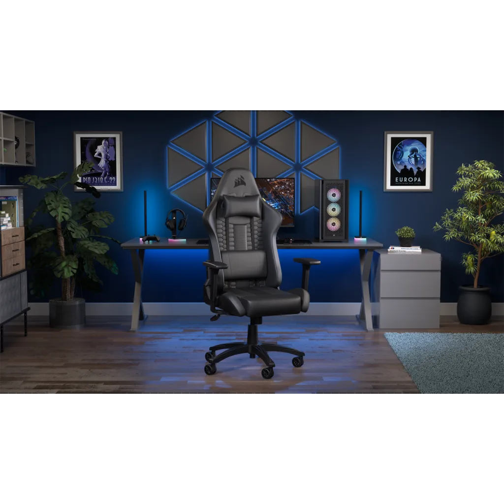 Játékbeállítás fekete gamer székkel, asztallal, számítógéppel, két keretezett poszterrel, kék falon.