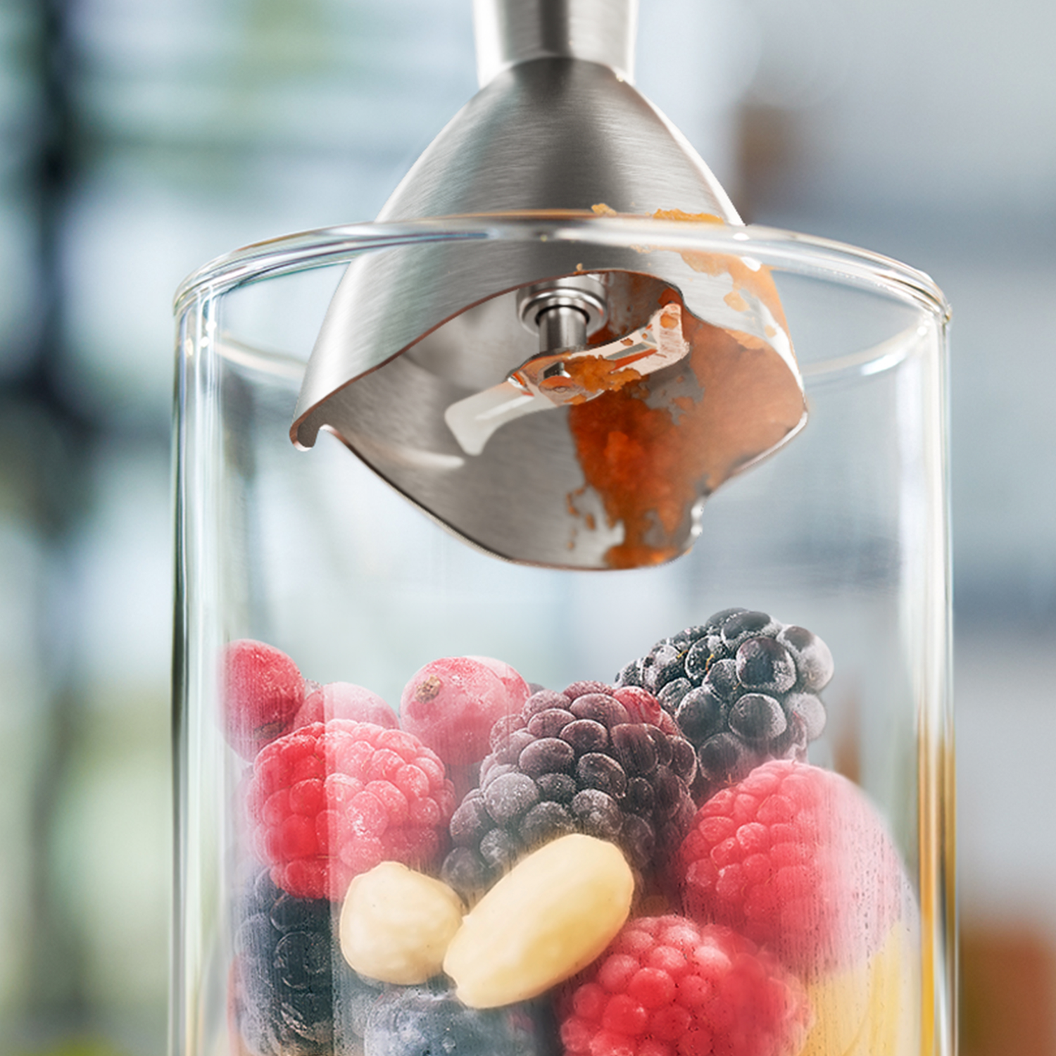 Blender met bessen en smoothie-ingrediënten. Roestvrijstalen mes is zichtbaar in het glas.