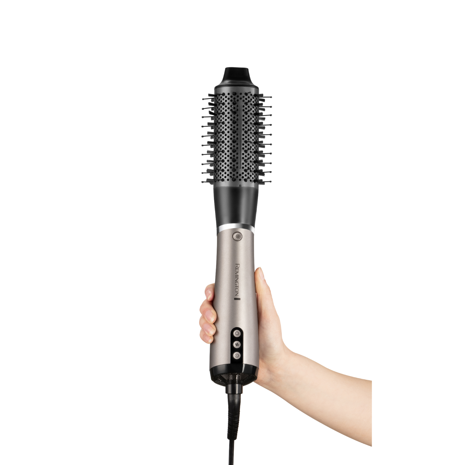 Hand holding a Remington hair dryer brush. Silver and black with black cord.