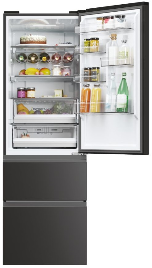 Otwarta czarna lodówka z półkami pełnymi jedzenia: słoiki, butelki, ciasto i szuflady z owocami i warzywami.