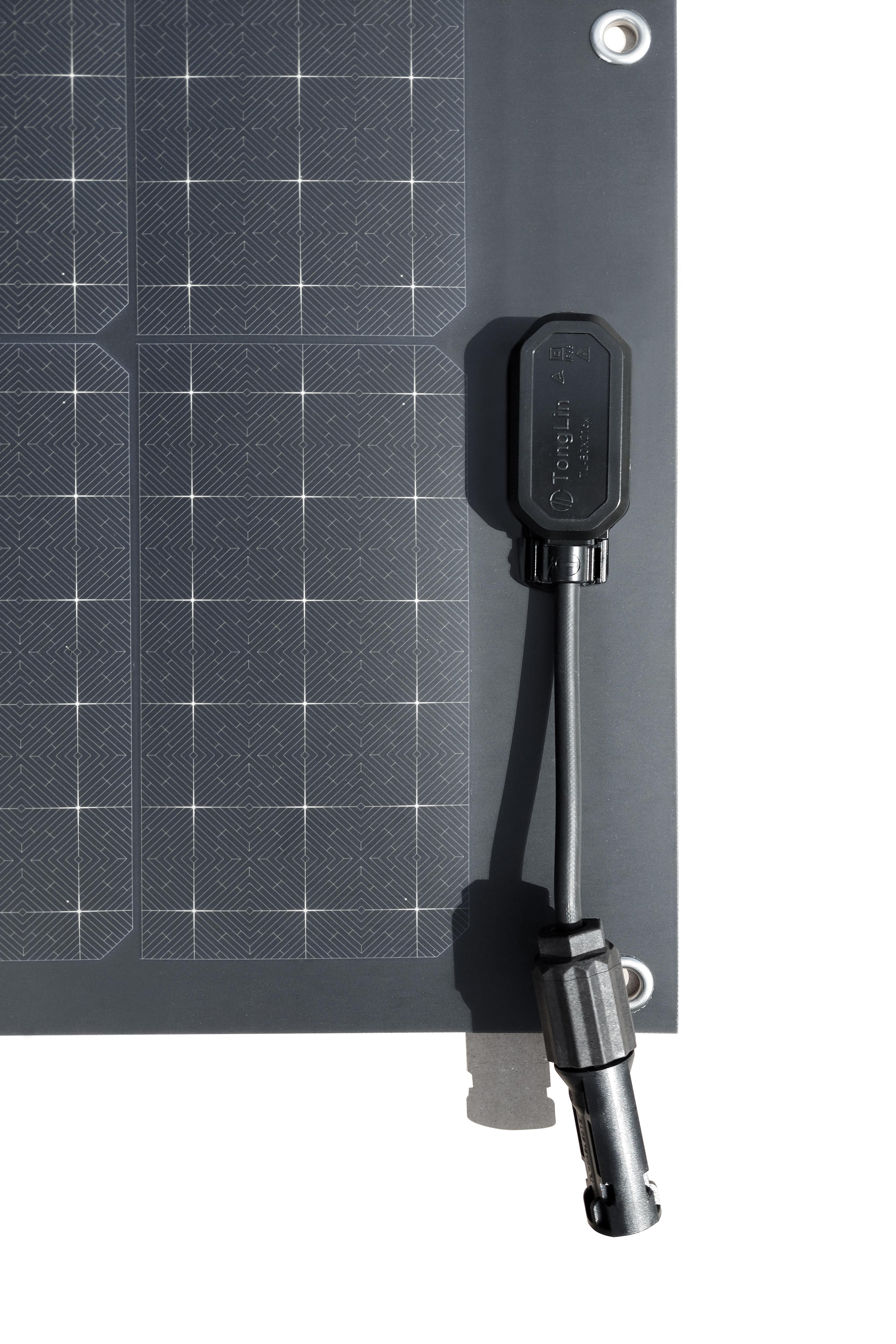 Solarpanel mit schwarzem Kabel und Stecker. Das Panel hat ein Rastermuster und befindet sich auf weißem Hintergrund.
