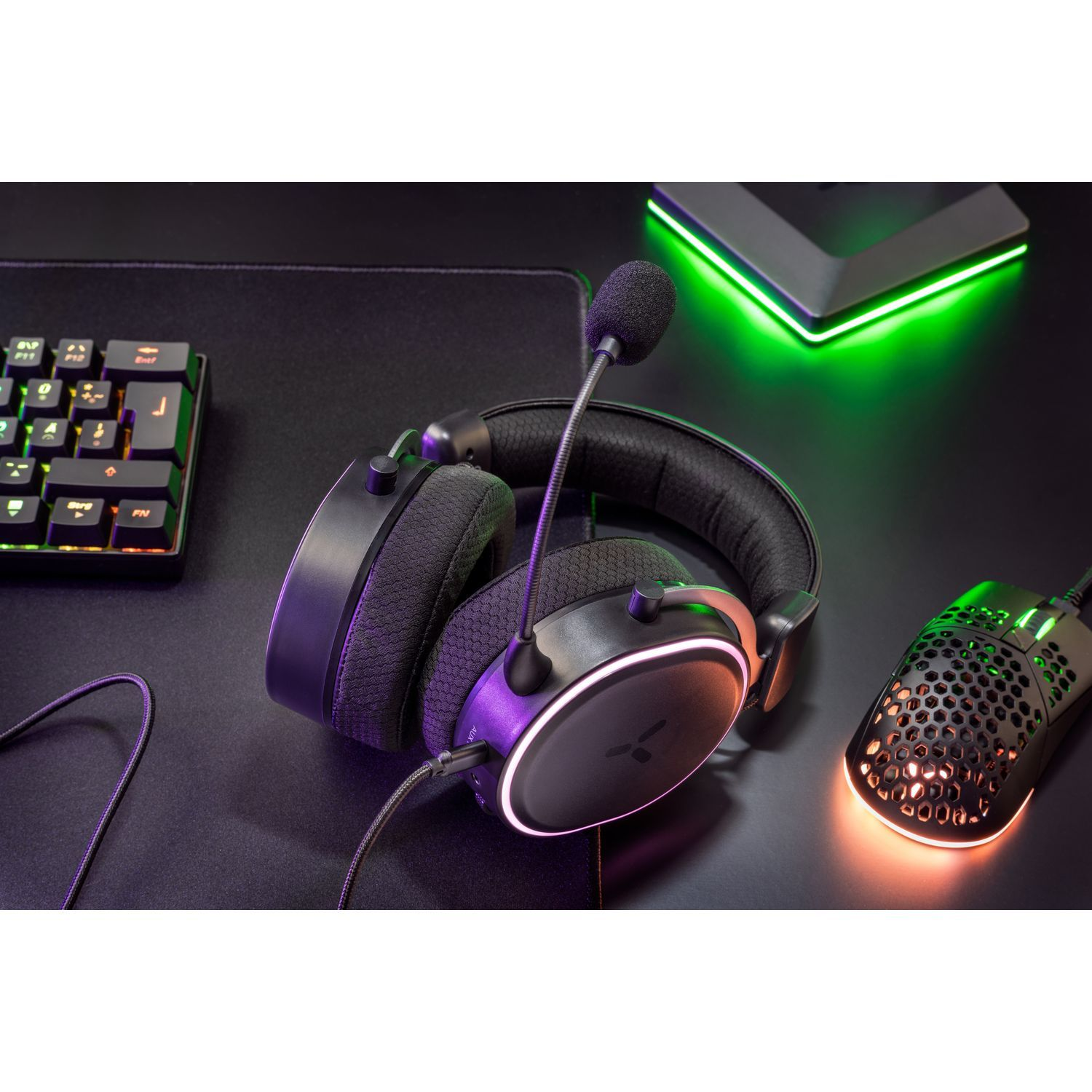 Headset and mouse on a black surface. Keyboard is also present in the background.