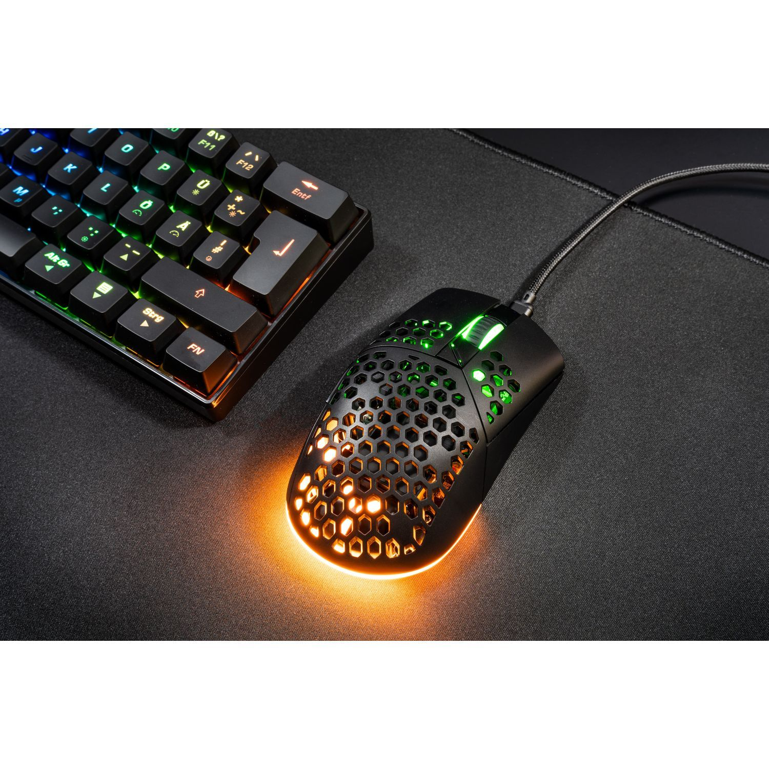 Gaming mouse and keyboard. Black mouse with honeycomb design, RGB lights. Keyboard with lights.