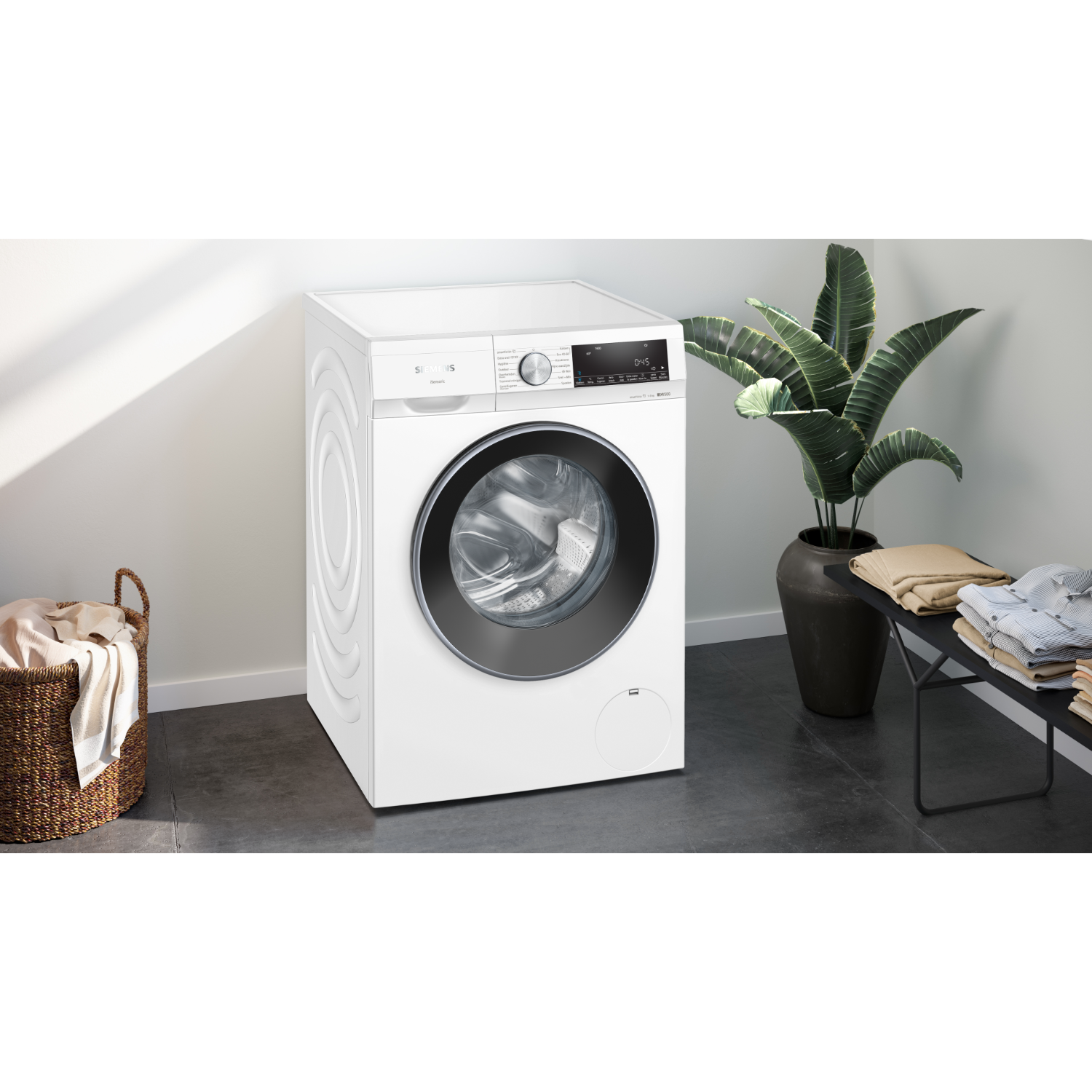 A white washing machine with a closed door in a room.
