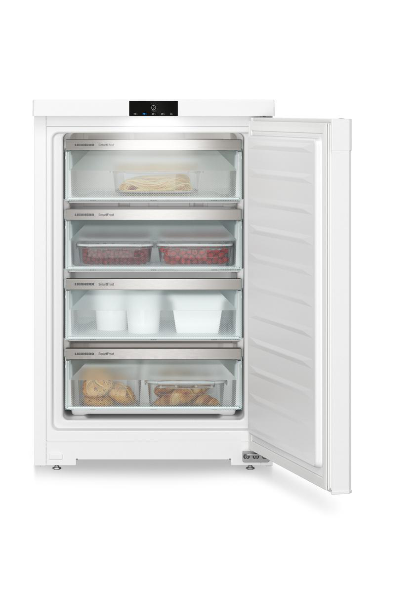Weißer Kühlschrank mit offener Tür, Schubladen mit Lebensmitteln zeigend. Hintergrund ist eine weiße Wand.