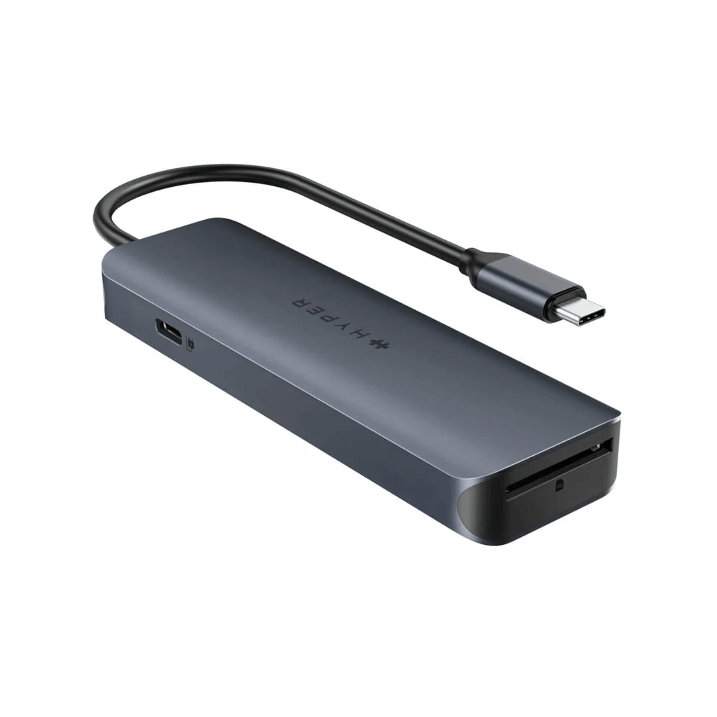 Un concentrador USB-C gris. Tiene un conector USB-C, HDMI y una ranura para tarjetas SD. Producto sobre fondo blanco.
