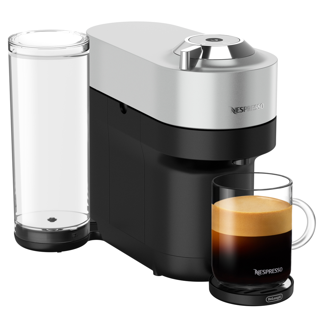 Eine silber-schwarze Nespresso-Maschine mit einem Glas Kaffee auf einem schwarzen Untersetzer.
