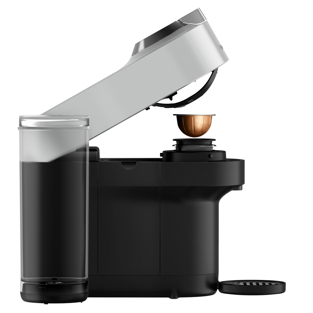 Eine schwarz-silberne Kaffeemaschine. Eine Kaffeekapsel wird eingesetzt.